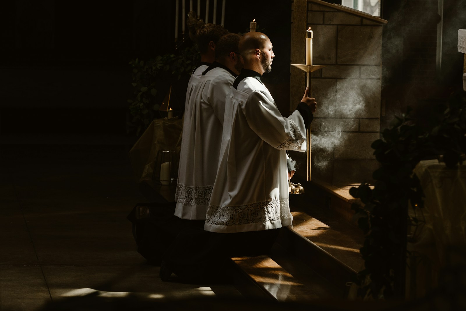Candle-bearers standing in the light inside a church